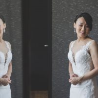 Yuri posing in front of glass window in her wedding dress.